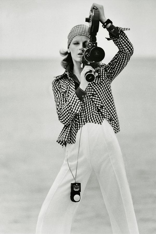Chic Cinematic Moment Photograph - A Model Looking Through A Beaulieu Camera Wearing by Gianni Penati