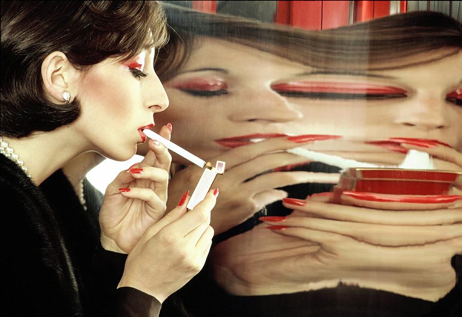 Woman Reflecting on a Cigarette Photograph - Anjelica Huston Lighting A Cigarette by Bob Stone