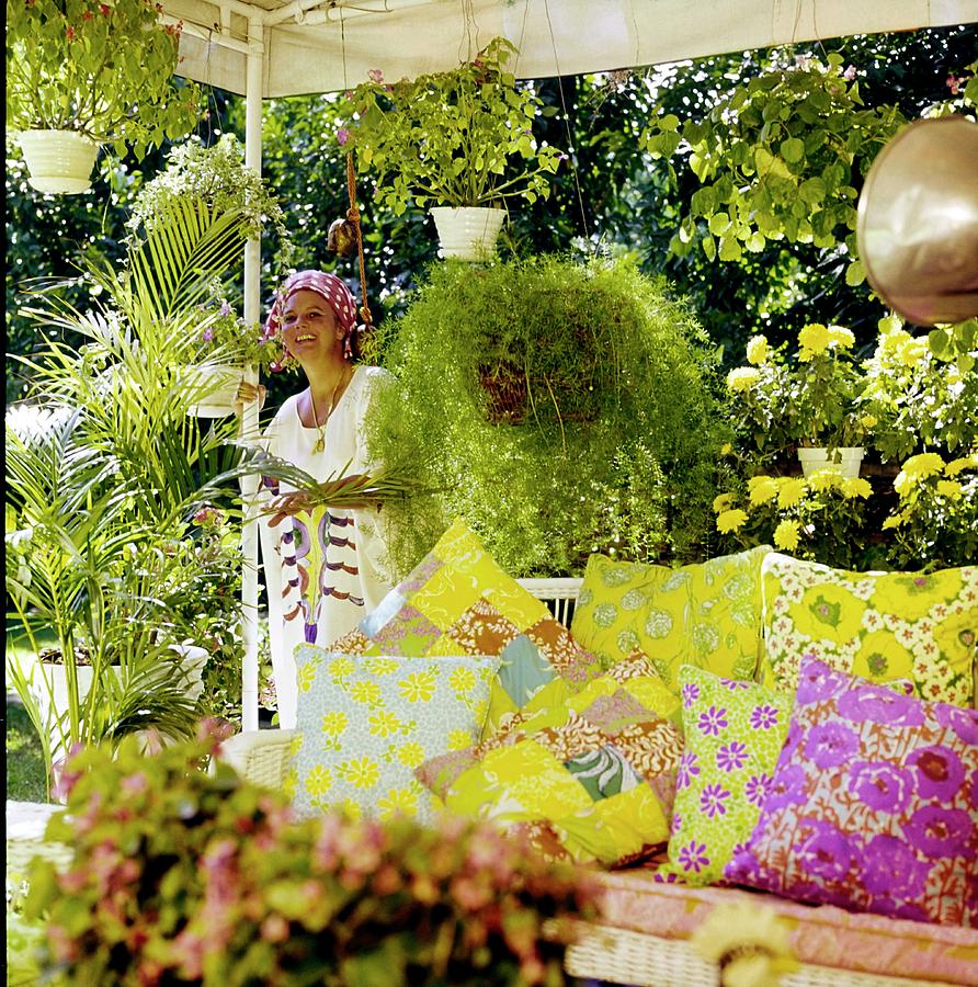 Vibrant Garden Oasis with Floral Cushions Photograph - Lilly Pulitzer In Her Garden by Horst P. Horst