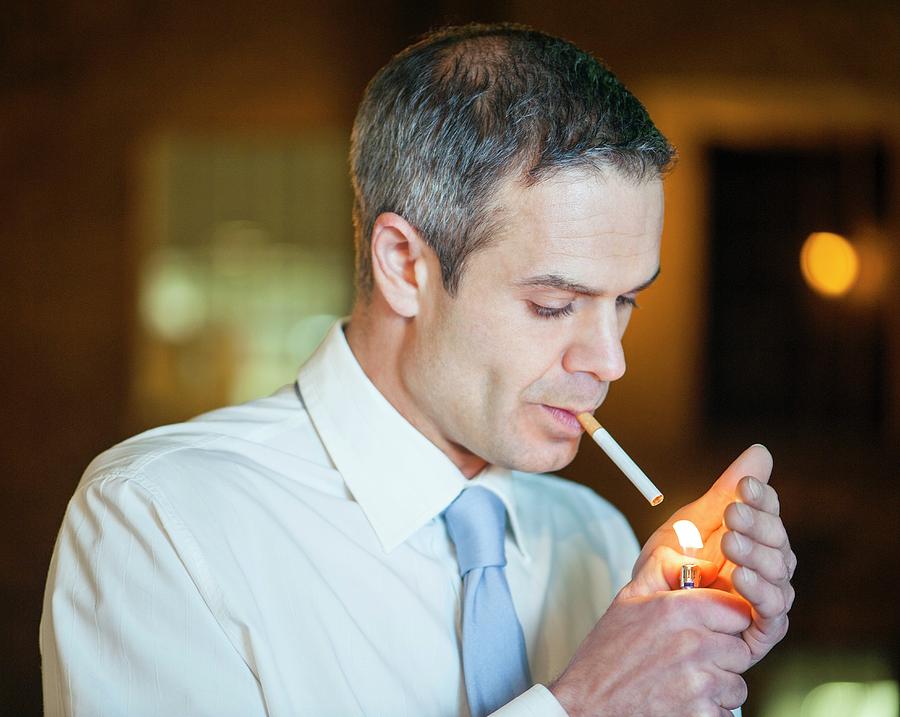 lighting a cigarette with another cigarette Man Lighting A Cigarette by Science Photo Library
