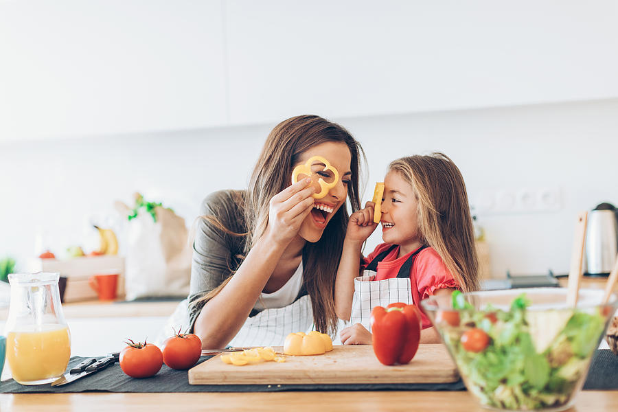 Mother and daughter having fun with the vegetables Photograph by Petar Chernaev
