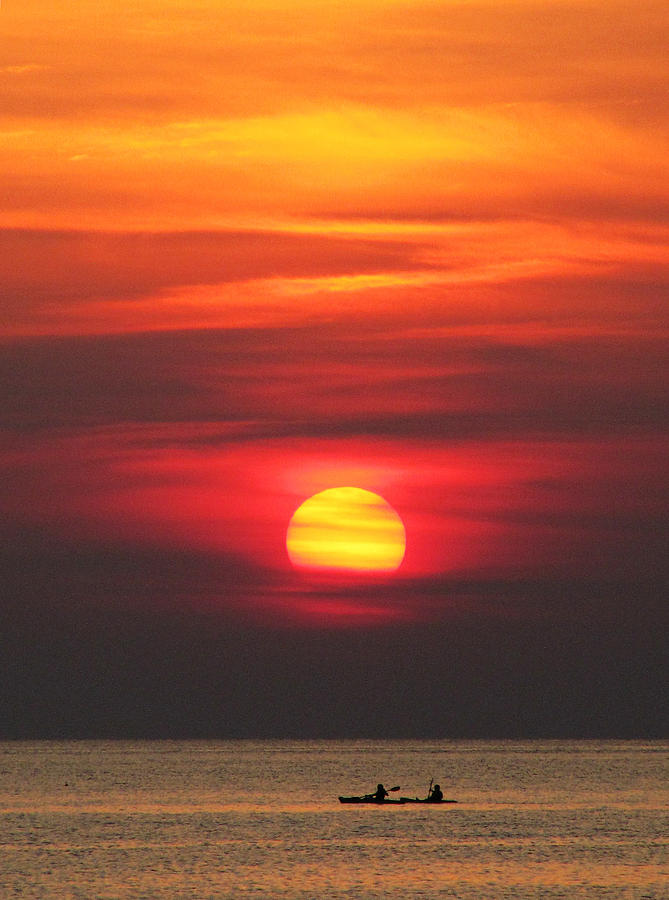 Paddling under the sun Photograph by Richard Reeve
