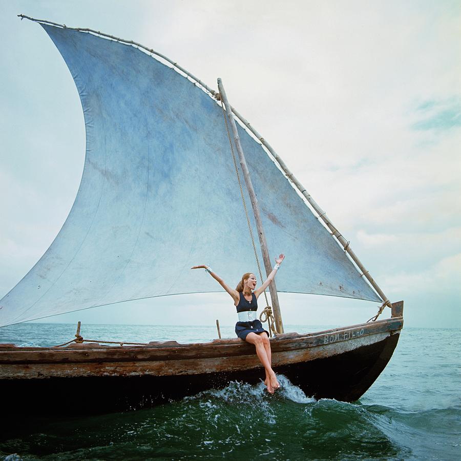 Woman Sailing on a Traditional Boat Photograph - Veruschka Von Lehndorff Sitting On Edge by Franco Rubartelli