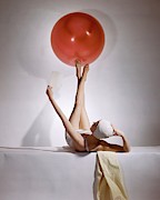 A Model Balancing A Red Ball On Her Feet Photograph by Horst P Horst