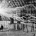Nikola Tesla, Inventor, sitting in his laboratory with electrical arcs above him
