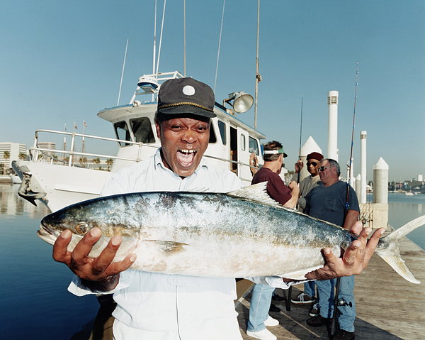 Mature Man Holding Yellowtail Fish On Jigsaw Puzzle by Sean Murphy