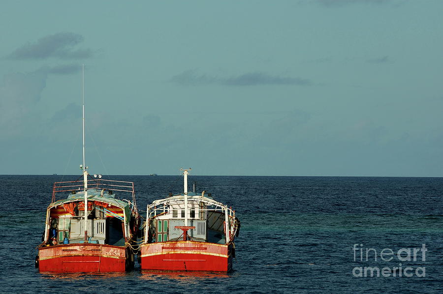 Two red fishing boats moored side by side in the blue ocean Photograph by Sami Sarkis Photography