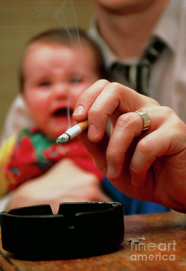 Passive Smoking: Man Smokes While Holding Baby #1 by Conor Caffrey /  Science Photo Library