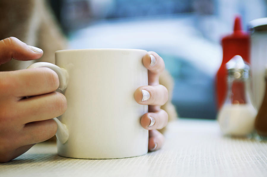 Close Up Of Hands Holding Cup Of Coffee by Tara Moore