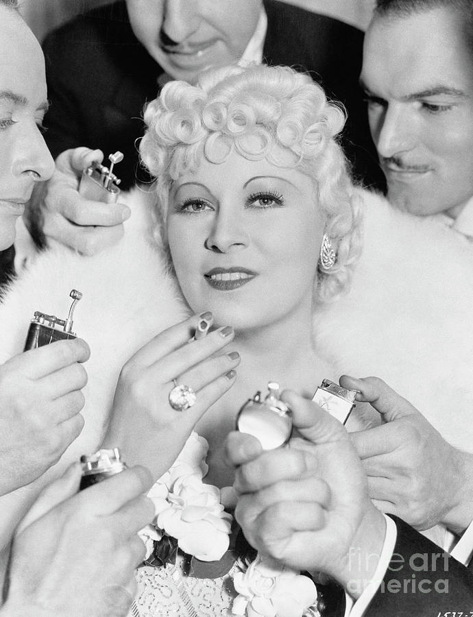 Men Offering To Light Cigarette For Mae by Bettmann