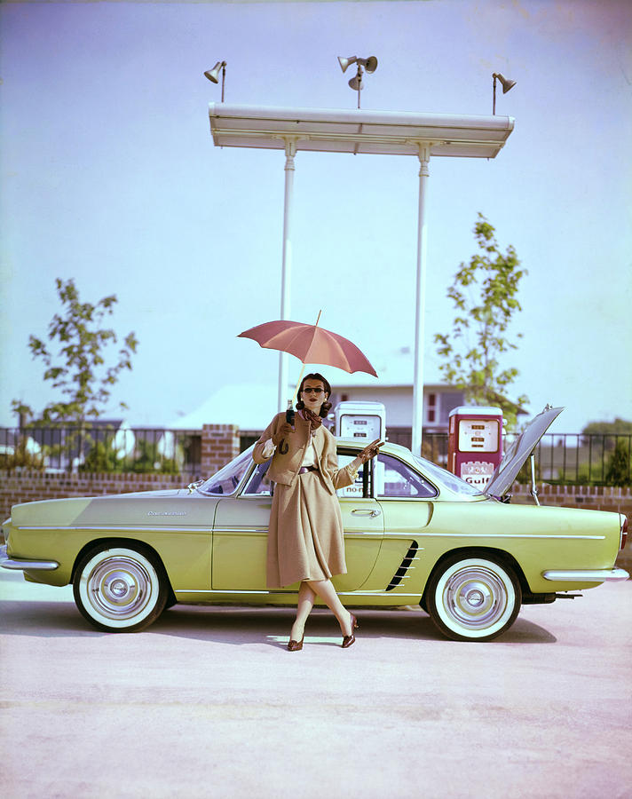 Vintage Car at Gas Station Photograph - Model in Front of a Gold Renault Caravelle by Jerry Schatzberg
