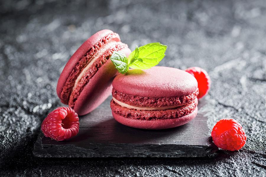 Raspberry Macaroons On A Black Stone Photograph by Shaiith