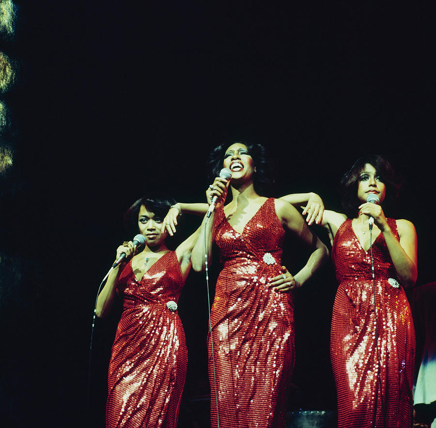 Three Women Performing in Red Dresses Photograph - The Supremes Perfom On Stage by David Redfern