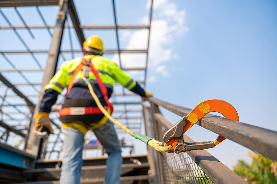 A construction worker working at height, Construction workers are working on steel roof trusses with Fall arrestor device for worker with hooks for safety body harness on the construction site. #6 Photograph by Pramote Polyamate
