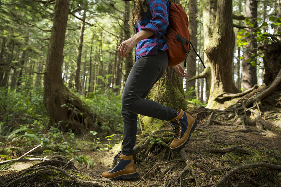 A woman hiking in a dense forest. Photograph by Jordan Siemens