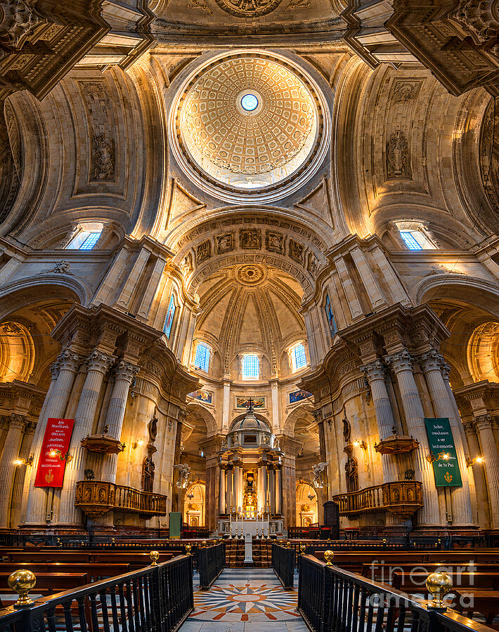 Photograph of the interior of Cadiz Cathedral by Sapiens Verbum: the stone dome with its oculus, the apse arch, the high altar, two wooden pulpits and a star-shaped marble floor