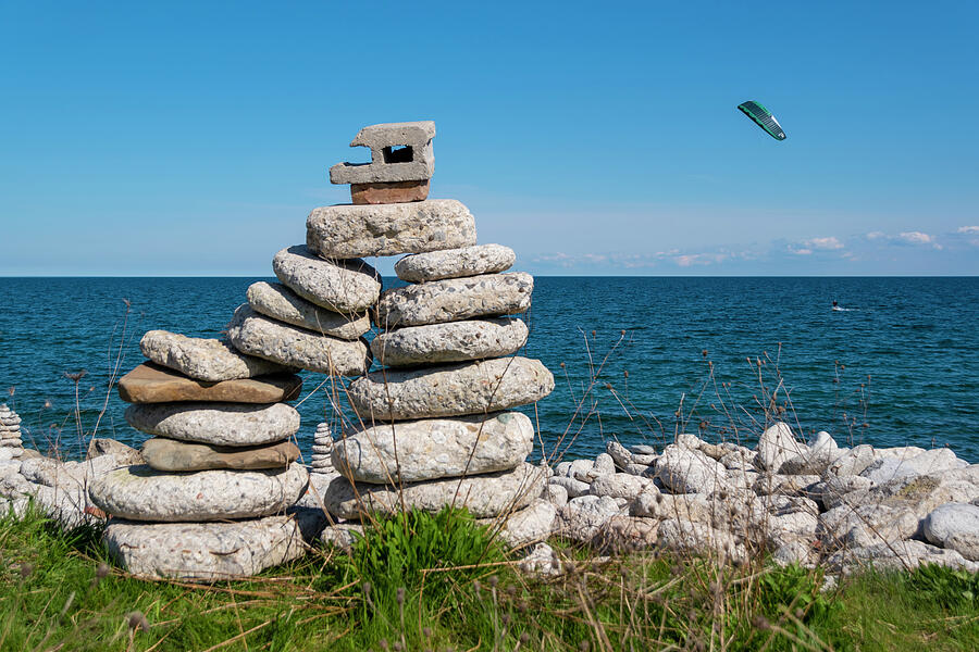 Large Inukshuk by a Lake with Parasailor Photograph by John Twynam