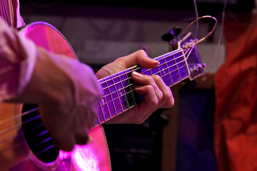 Man playing an acoustic guitar on stage Photograph by Rapeepong Puttakumwong