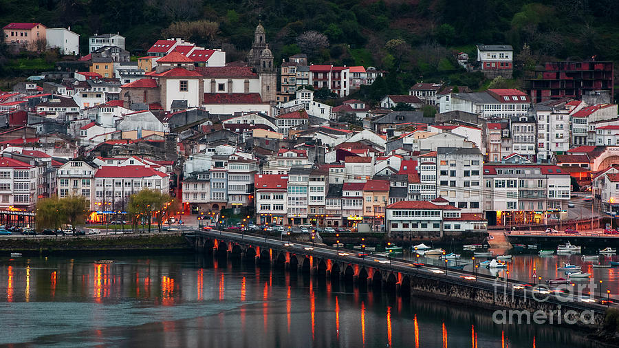 Medieval fishing town of Pontedeume with its stone bridge by night, A Coruña, Galicia: the original photograph with the lit town and the bridge lamps reflected in the estuary