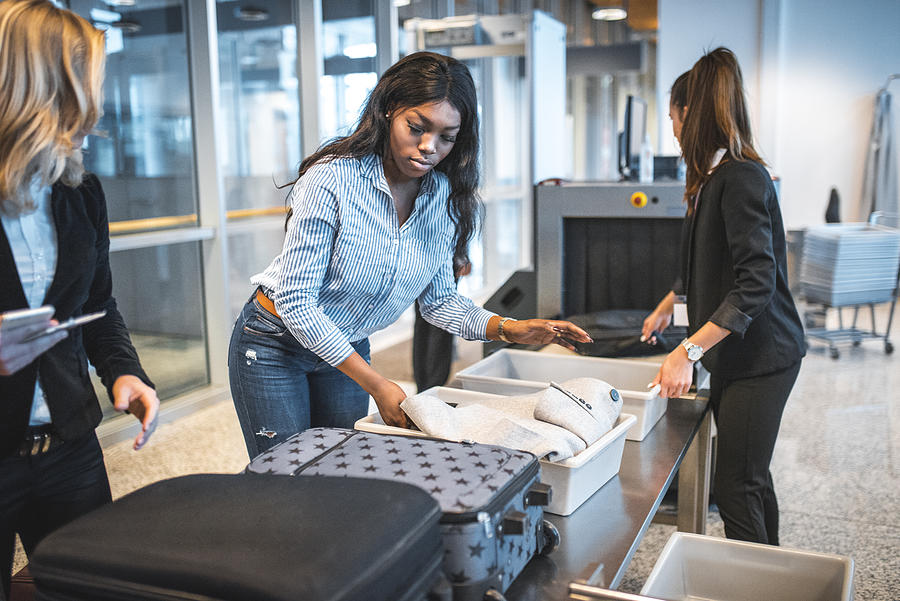 People with luggage at security check in airport Photograph by AzmanL