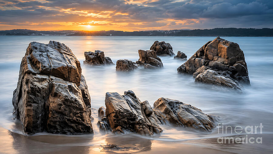 Long-exposure sunset over dark rocks and misty tide at Seselle Beach, Ares, Galicia, Spain