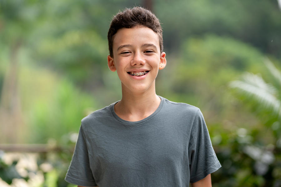 Teen boy with braces smiling outside in summer Photograph by Giselleflissak