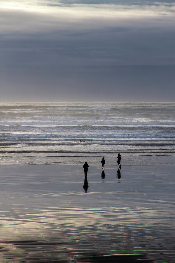 People Walking on Beach at Dusk Photograph - Trio of Reflections at Lahinch by Mark Callanan