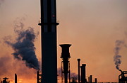 Smoking chimneys of a petroleum refinery at sunset Photograph by Sami Sarkis Photography