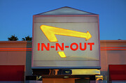 Illuminated In-N-Out Burger sign with a yellow arrow and red text at sunset Photograph by Miroslav Liska