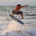Gio Skimboarder Jumping Over Ocean Waves by Donn Ingemie